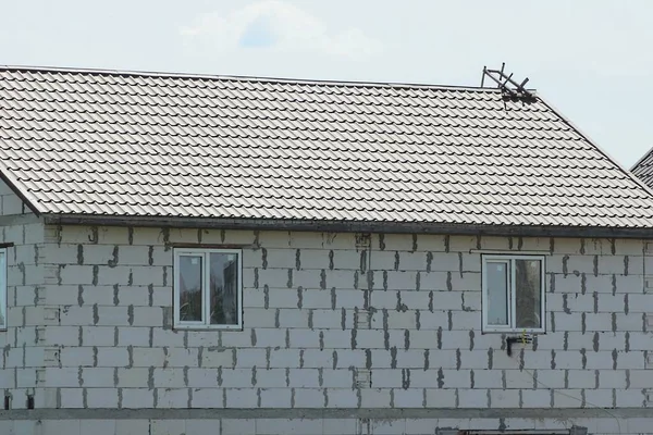 Kahverengi Kiremitli Çatının Altında Gri Gökyüzüne Bakan Beyaz Tuğlalı Bir — Stok fotoğraf