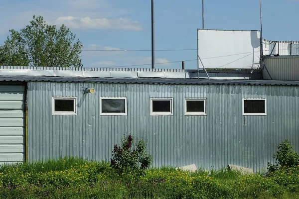 Pared Metal Gris Edificio Industrial Hierba Verde Contra Cielo Azul —  Fotos de Stock