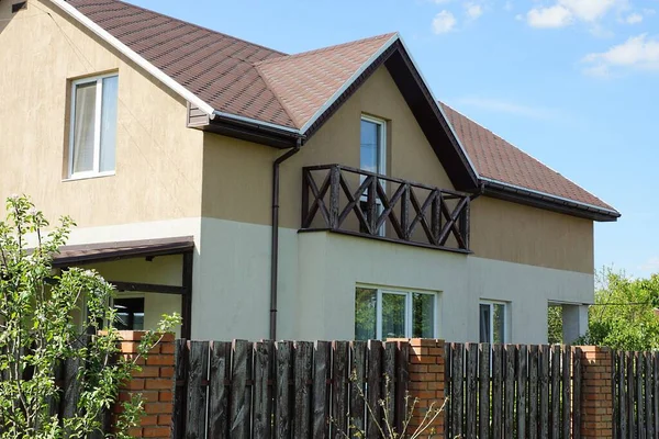 Açık kahverengi ahşap balkon özel bir evin duvarında fayanslı bir çatının altında.