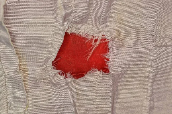 Textura Tkaniny Kusu Šedého Zmačkaného Oblečení Červenou Dírou — Stock fotografie
