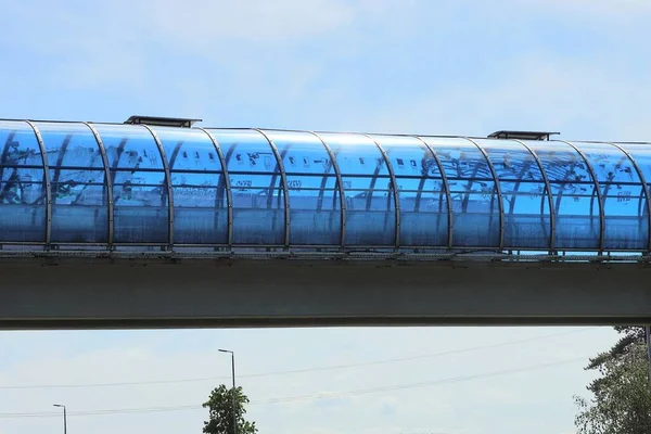 하늘을 배경으로 콘크리트 플라스틱 터널을 가로지르는 보행자의 — 스톡 사진