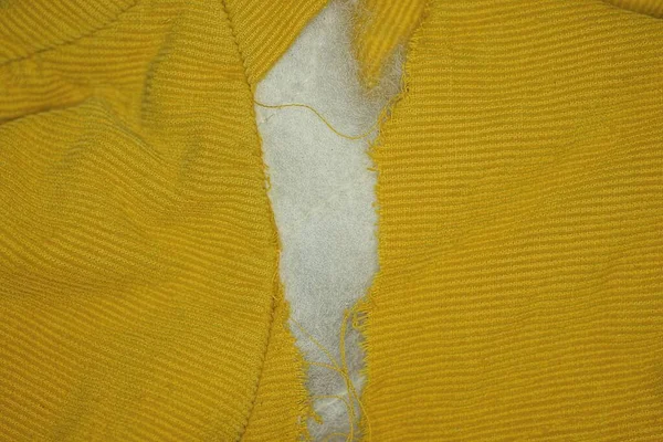 Jeden Duży Otwór Białą Wełną Bawełnianą Żółtym Materiale Starej Kurtki — Zdjęcie stockowe