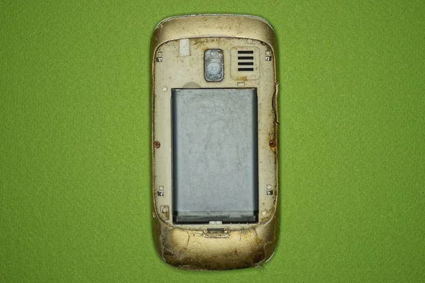 Один Старий Брудний Відкритий Мобільний Телефон Сірою Батареєю Лежить Зеленому — стокове фото