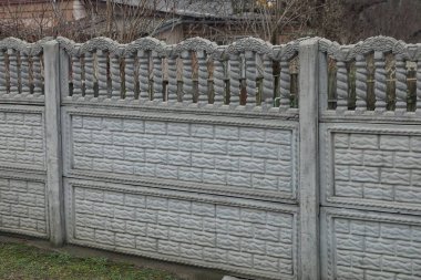 part of a gray rural private fence wall made of concrete in the street