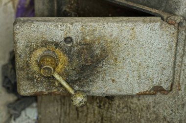 part of an old metal gray heating boiler with an iron dirty open door with a handle in the room