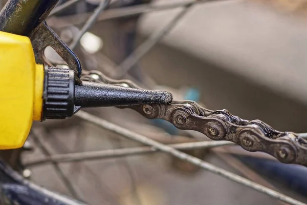 一只黄色的黑色塑料管把生锈的灰色链子绑在一辆旧自行车上 — 图库照片