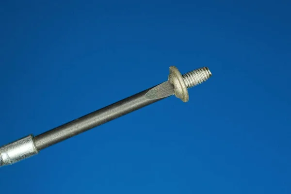 Black Metal Screwdriver One Small Gray Screw Blue Background — Stock Photo, Image