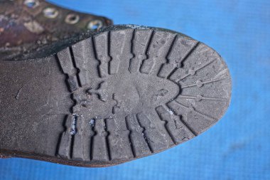 Eski bir botun parçası. Mavi arka planda gri kirli bir plastik tabandan.