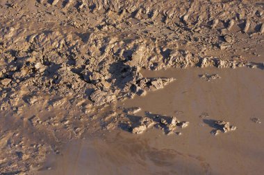 Kahverengi kil ve yoldaki çamurlu suyun doğal dokusu.