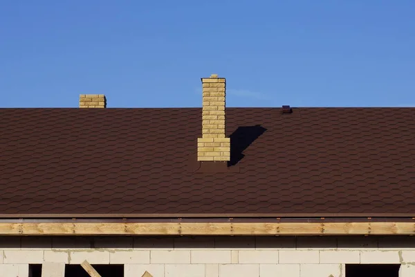 青い空に面した民家の茶色い瓦屋根の上の煙突レンガ — ストック写真