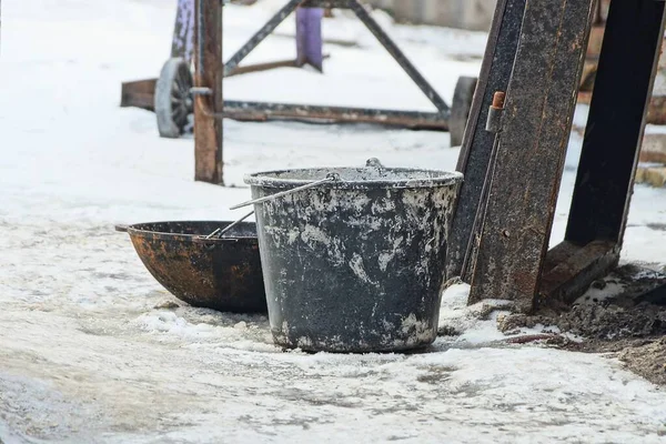Vecchio Secchio Sporco Nero Una Ciotola Ferro Poggiano Sulla Neve — Foto Stock
