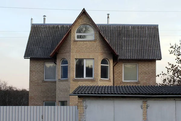 一座褐色砖造的私宅的立面 窗户在灰色石板屋顶下 蓝天衬托下 — 图库照片