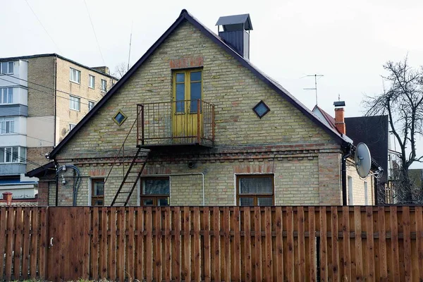 旧的乡村褐色砖房的立面 在木制栅栏后面有一个敞开的铁阳台 — 图库照片