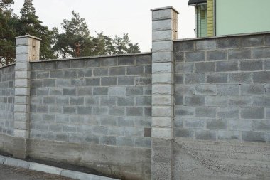 Kırsal bir sokakta gri tuğlalardan yapılmış bir çit parçası.