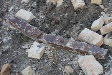 Eski tuğlalardan ve paslı kahverengi demir kirişlerden gelen çöpler sokakta gri zeminde yatıyordu.