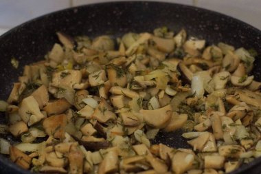 Kızarmış mantar parçalı siyah tava.