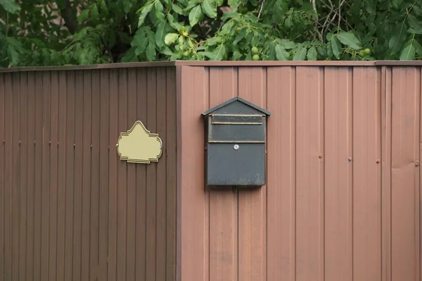 Egy Régi Fekete Postaláda Lóg Egy Barna Fém Kerítés Falán — Stock Fotó