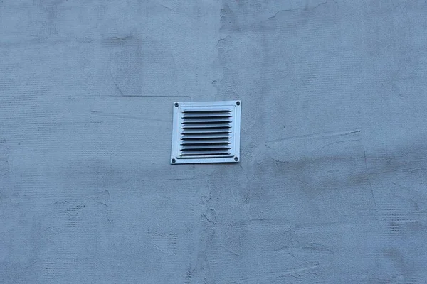 室外灰色混凝土墙壁上的一个正方形金属风扇格栅 — 图库照片