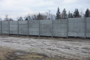 Sokakta betondan yapılmış gri, kırsal bir çit.