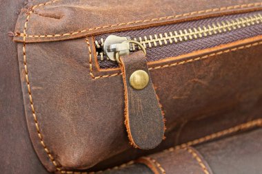 gray closed metal zip on brown leather bag pocket