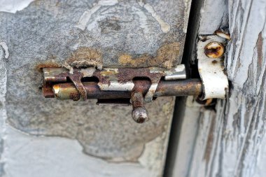 Kapalı eski gri metal bir mandal beyaz ahşap bir kapı üzerinde