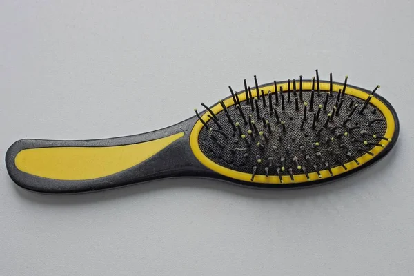 One Large Plastic Black Yellow Dirty Hairbrush Lies White Table — Stockfoto