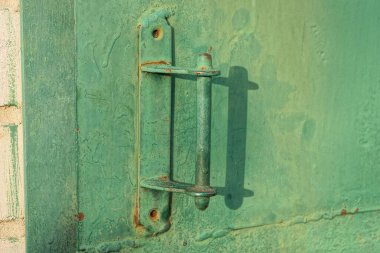Bir yeşil metal kapı tokmağı kirli bir demir kapı ve sokakta bir duvar