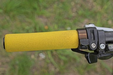 ... el freni ve sarı plastik saplı siyah metal bisiklet gidonunun bir parçası.