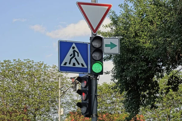 Стовп Дорожніми Знаками Світлофорами Вулиці Тлі Блакитного Неба Зелених Дерев — стокове фото