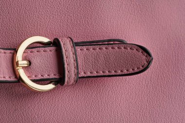 Deri bir çantanın kayışında yüzük olan sarı metal bir mandal.