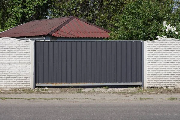 Una Gran Puerta Metal Negro Cerrado Una Pared Ladrillo Blanco — Foto de Stock