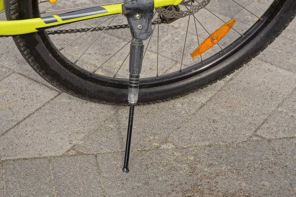 スポーツバイクの一部は道路の灰色の舗装の車輪の近くの黒い鉄の自転車の足台の上に立っています — ストック写真