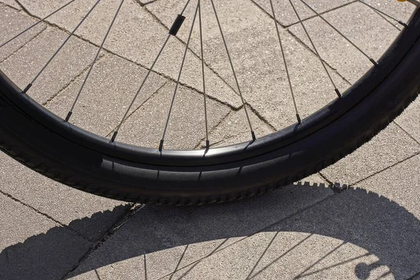 Parte Uma Roda Bicicleta Preta Com Raios Metal Fica Pavimento — Fotografia de Stock