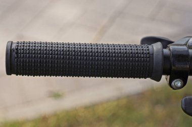 Spor bisikletinin gidonunda gri bir arka planda siyah bir plastik tutuş.