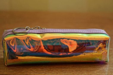 Odadaki kahverengi bir masada uzun, kapalı bir plastik çanta duruyor.