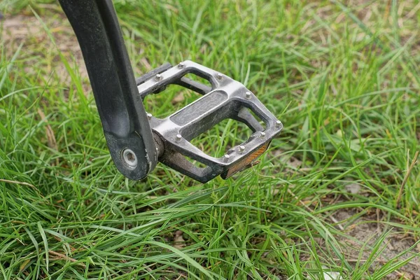 Een Zwart Pedaal Een Fiets Achtergrond Van Groen Gras Straat — Stockfoto