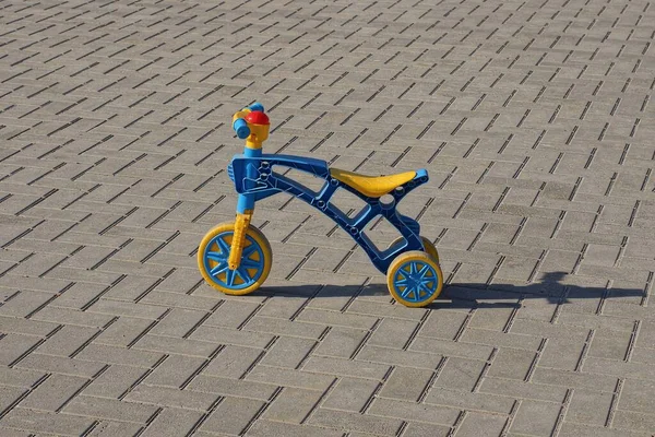 Jeden Mały Plastikowy Rower Trzykołowy Stoi Szarym Chodniku Ulicy — Zdjęcie stockowe