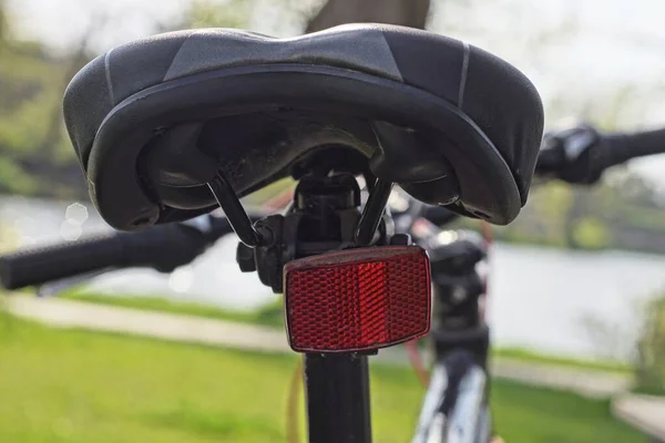 黑色自行车车架上的皮革鞍座 户外有红色反射镜 — 图库照片