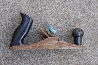 Siyah saplı kahverengi pas içindeki eski bir metal eklem gri bir masada yatıyor.