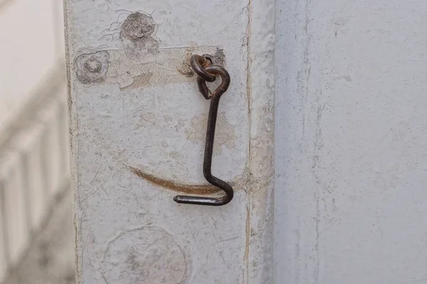 白色木门上的一个旧的褐色金属钩锁 — 图库照片