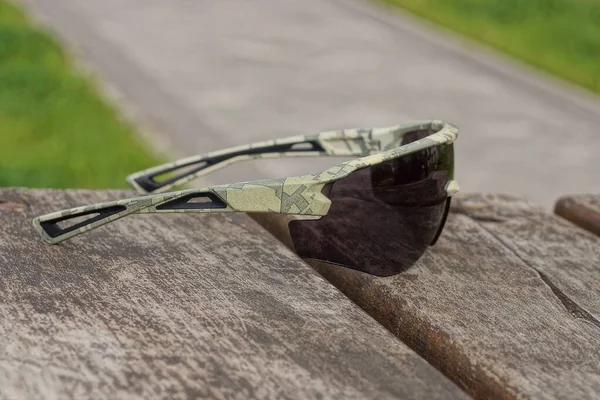 One Green Brown Sunglasses Lies Agray Wooden Table Street — Stock fotografie