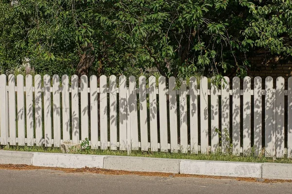 Lange Weiße Hölzerne Zaunmauer Freien Der Nähe Von Betonrandsteinen Grüner — Stockfoto