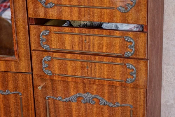 part of an old brown wooden cabinet with shelves and doors in the room