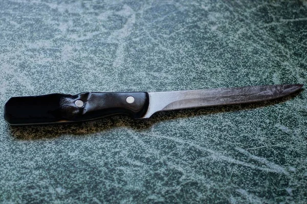 Один Старый Нож Черной Ручкой Лежит Зеленом Столе — стоковое фото
