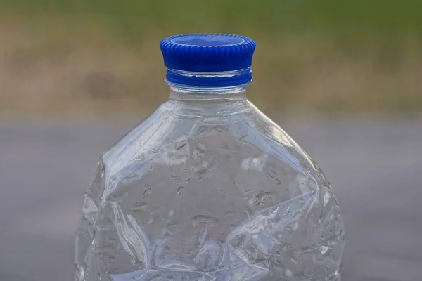 Часть Одной Пластиковой Мокрой Бутылки Закрытой Голубой Пробки Улице — стоковое фото