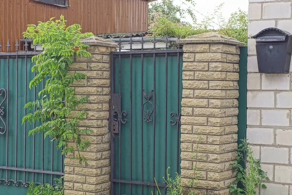 Zamknięte Zielone Metalowe Drzwi Czarnym Wzorem Kutego Żelaza Brązowej Ceglanej — Zdjęcie stockowe