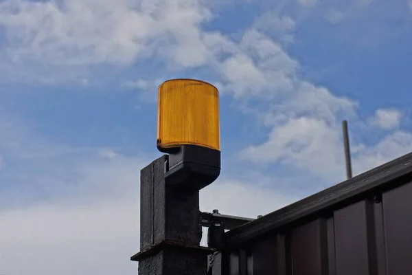 Egy Sárga Narancssárga Üveg Jelzőlámpa Egy Fekete Kerítés Falán Utcán — Stock Fotó