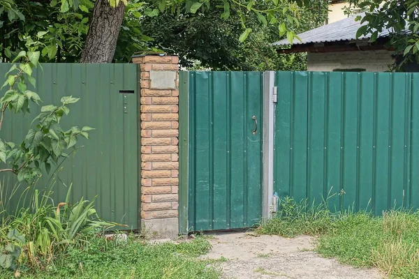One Green Closed Green Metal Door Brown Brick Iron Fence — Zdjęcie stockowe