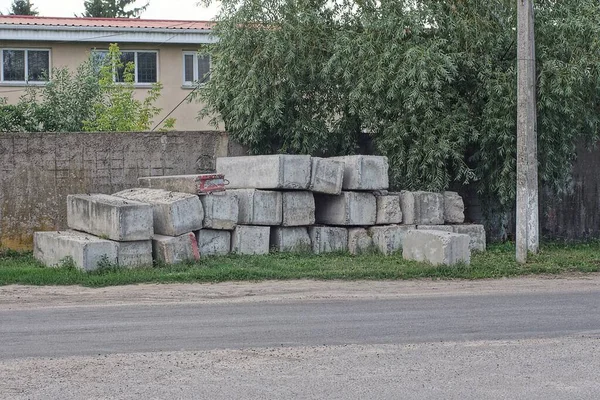 Pile Gray Concrete Blocks Wall Fence Green Grass Street Asphalt — стоковое фото