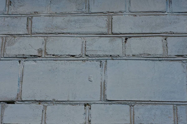 gray blue stone texture of dirty bricks in a building wall in the street